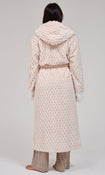 A person shown from the back wearing a long, textured hooded robe in a very light cream tone, paired with beige pants, against a plain light gray studio background.